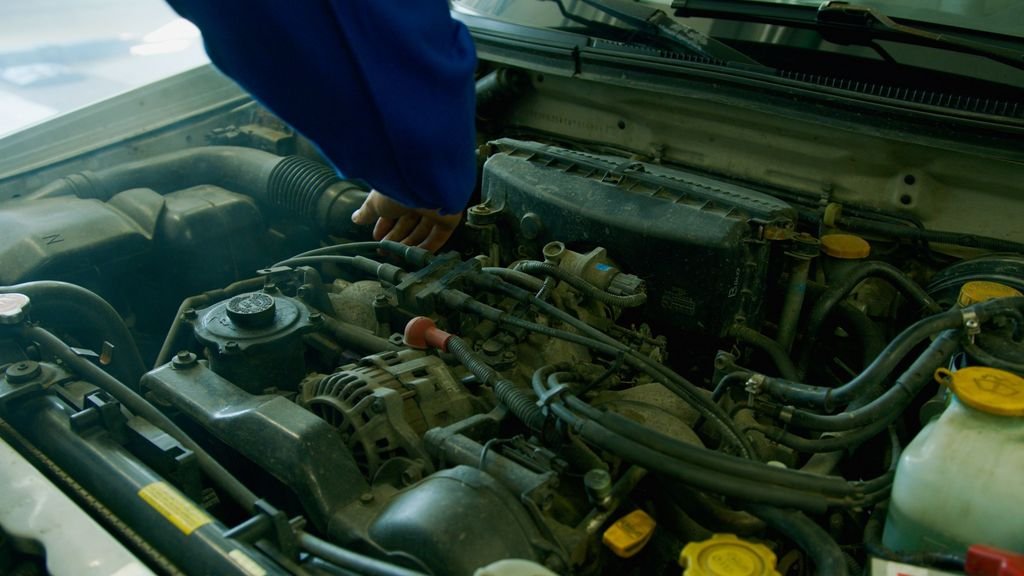 Mechanic repairing a vehicle engine in an automotive workshop